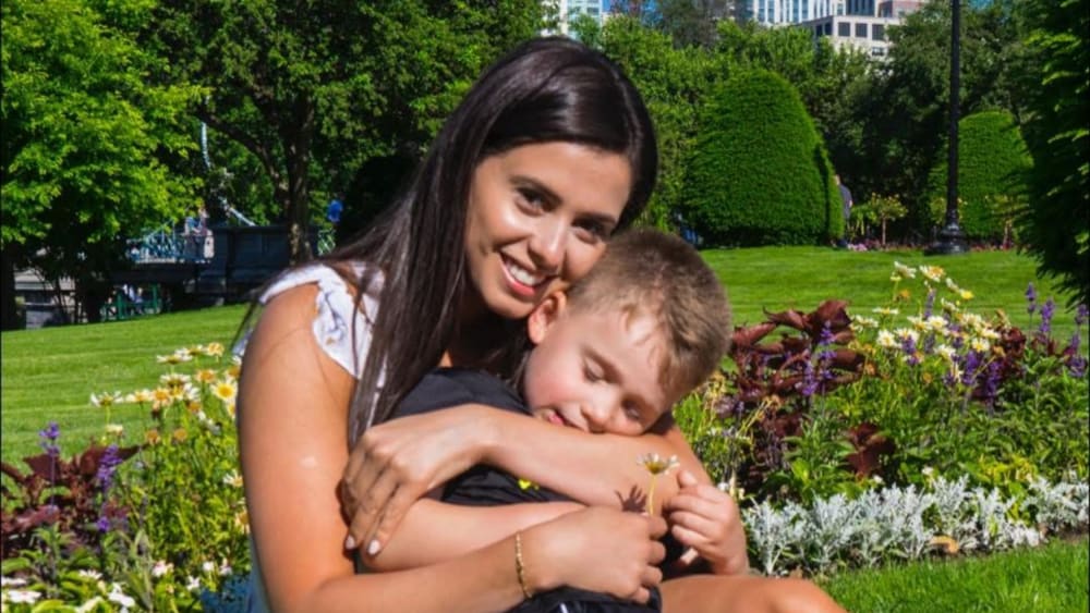 Bruna Ferreira and hugging her young son in a park