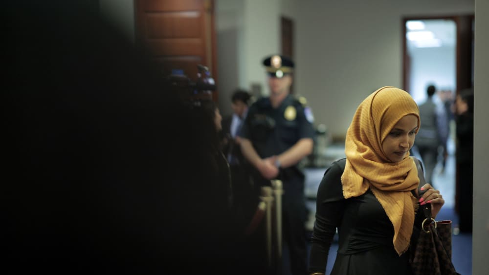 Rep. Ilhan Omar at the Capitol, with a police officer in the background