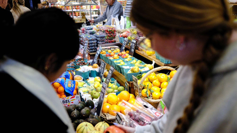 People shop for fruit in a grocery store ion NYC.