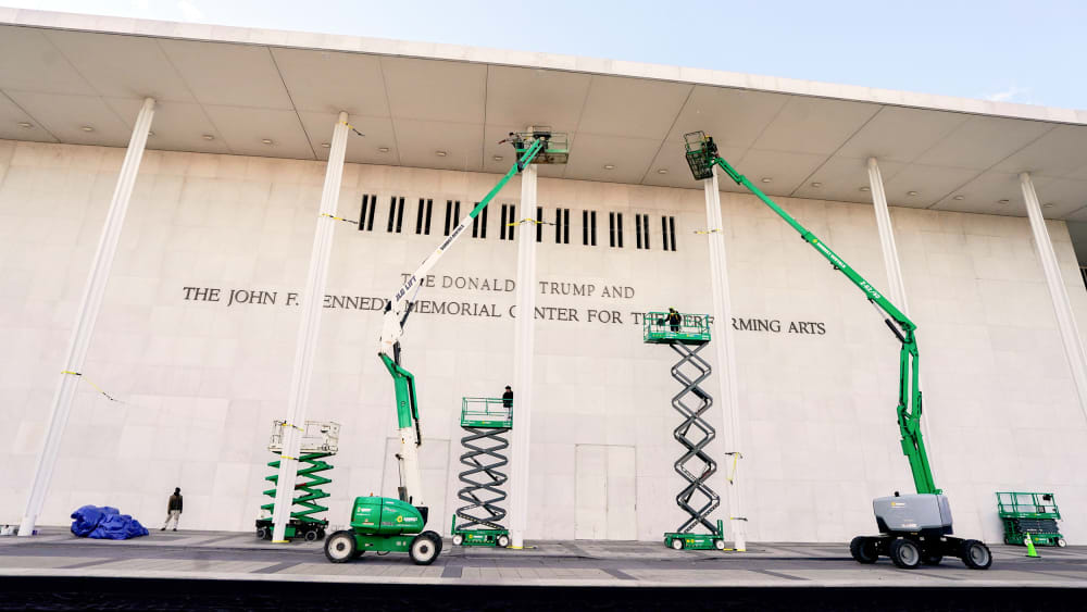 Workers affix signage adding US President Donald Trump's name on the facade of the Kennedy Center on Friday Dec. 19 in Washington, D.C.