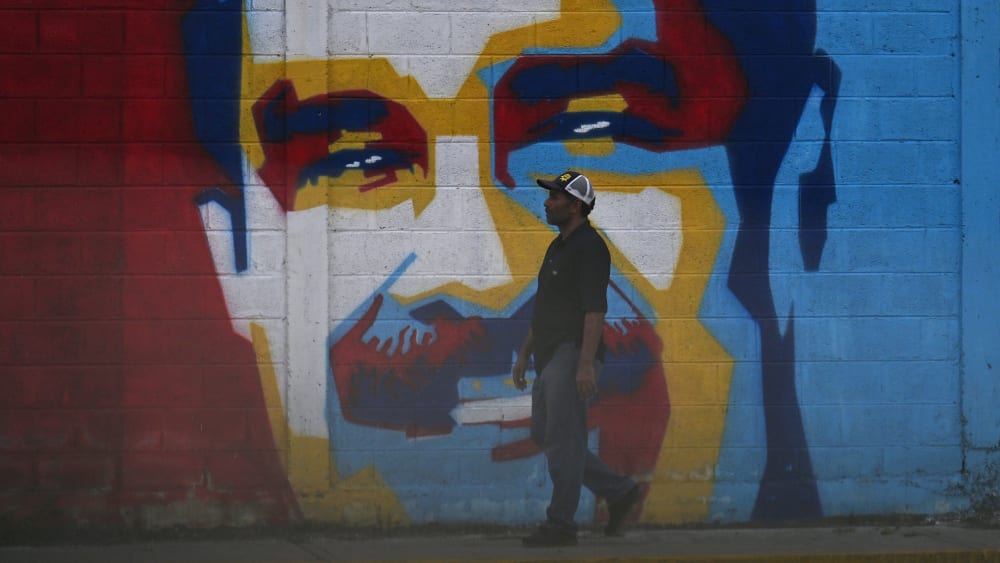 A man walks past a graffiti depicting Venezuelan President Nicolas Maduro in Caracas on January 3, 2026.