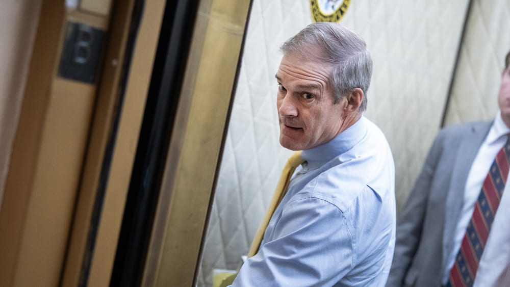 Rep. Jim Jordan pressing a button in the elevator while a young man stands behind him.
