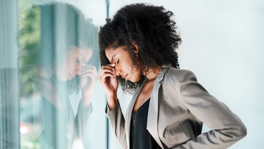 Shot of a young black businesswoman looking stressed out in an office.