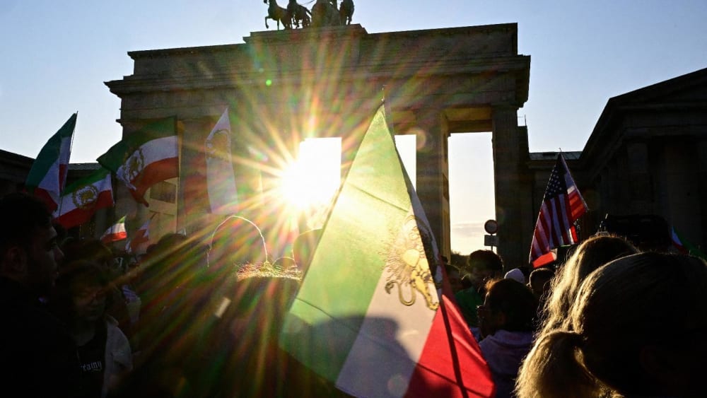 Protesters wave Iranian flags and shout slogans during a demonstration in Berlin, on Mar. 1, 2026.