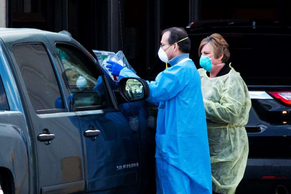 Image: People use a newly approved saliva-based coronavirus disease (COVID-19) test at a testing site in Edison, New Jersey