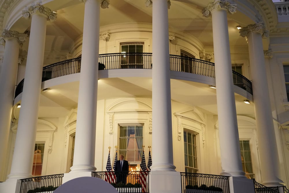 Image: President Donald Trump poses atop the Truman Balcony of the White House after taking off his mask as he returns from the Walter Reed Medical Center,