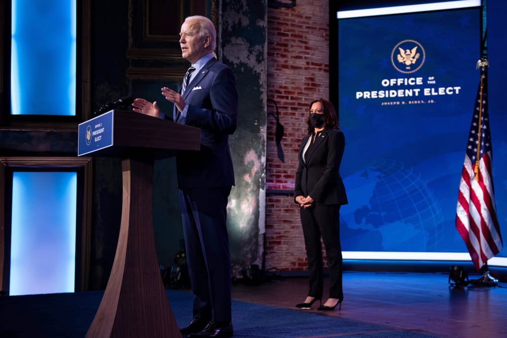 Vice President-elect Kamala Harris listens while as President-elect Joe Biden speaks at the Queen Theater on Dec. 28, 2020, in Wilmington, Del.