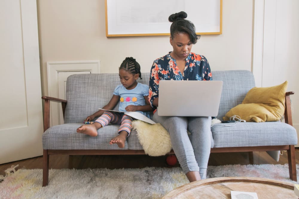 African American mother and daughter relaxing in living room