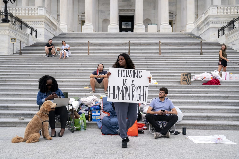 Rep. Cori Bush, D-Mo., center, joined by Congressional staffers and activists, protests the expiration of the eviction moratorium outside the Capitol on July 31, 2021.