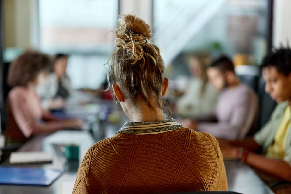 Back view of creative woman on a meeting in the office.
