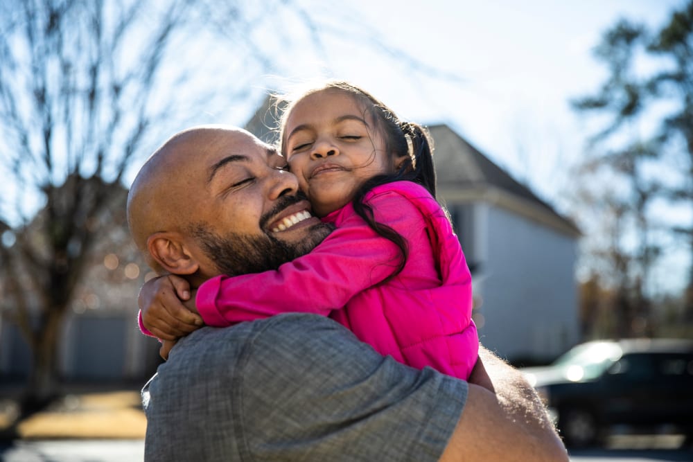 Father holding young daughter outdoors