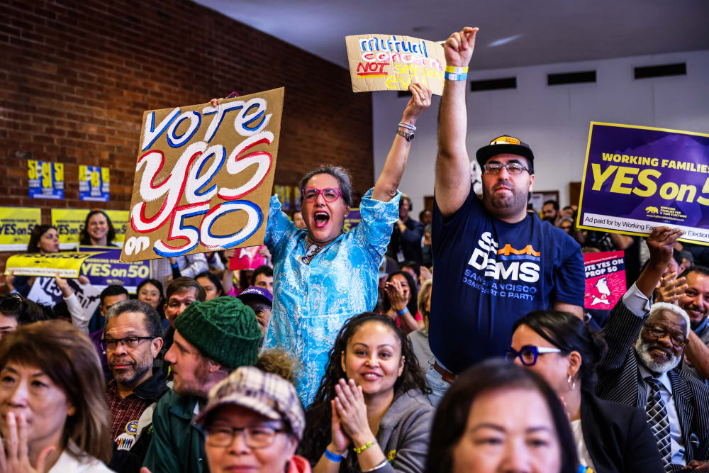 People cheer during a campaign event in support of Prop 50 in San Francisco.