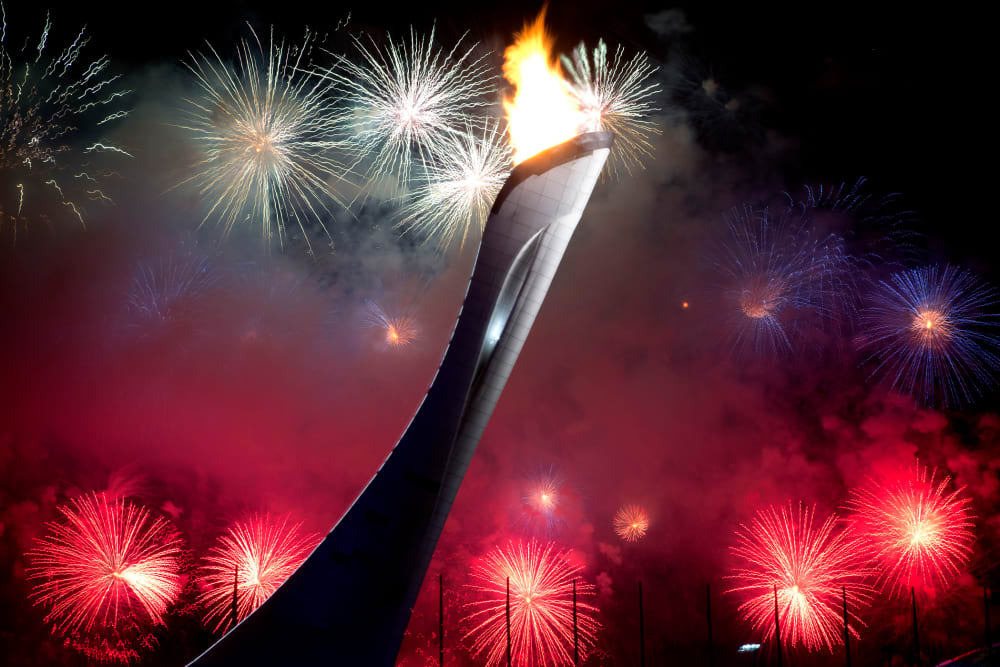 Fireworks explode behind the Olympic torch after it was lit at end of the opening ceremony for the 2014 Winter Olympics in Sochi, Russia, Feb. 7, 2014.