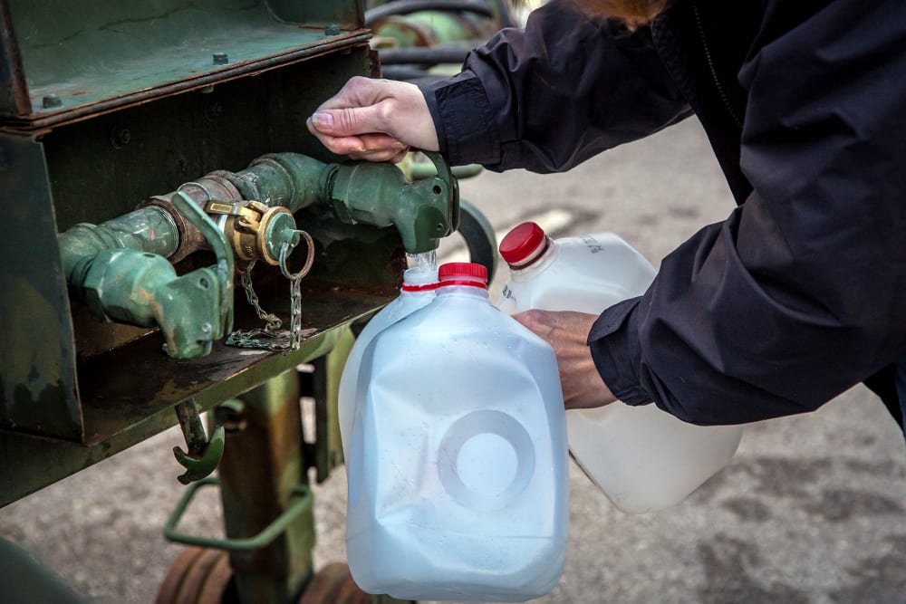 A local resident fills jugs with water at a distribution center in Charleston, W.Va., on Jan. 12, 2014.