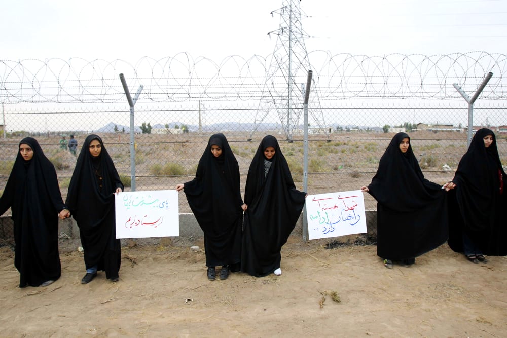 Iranian students form a human chain during a protest to defend their country's nuclear program outside the Fordo Uranium Conversion Facility in Qom, Nov. 19, 2013.