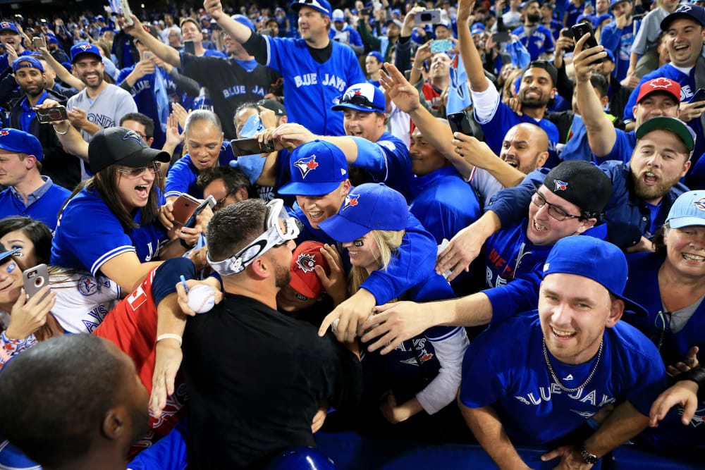 Marco Estrada #25 of the Toronto Blue Jays is swarmed by fans in Toronto, Canada.