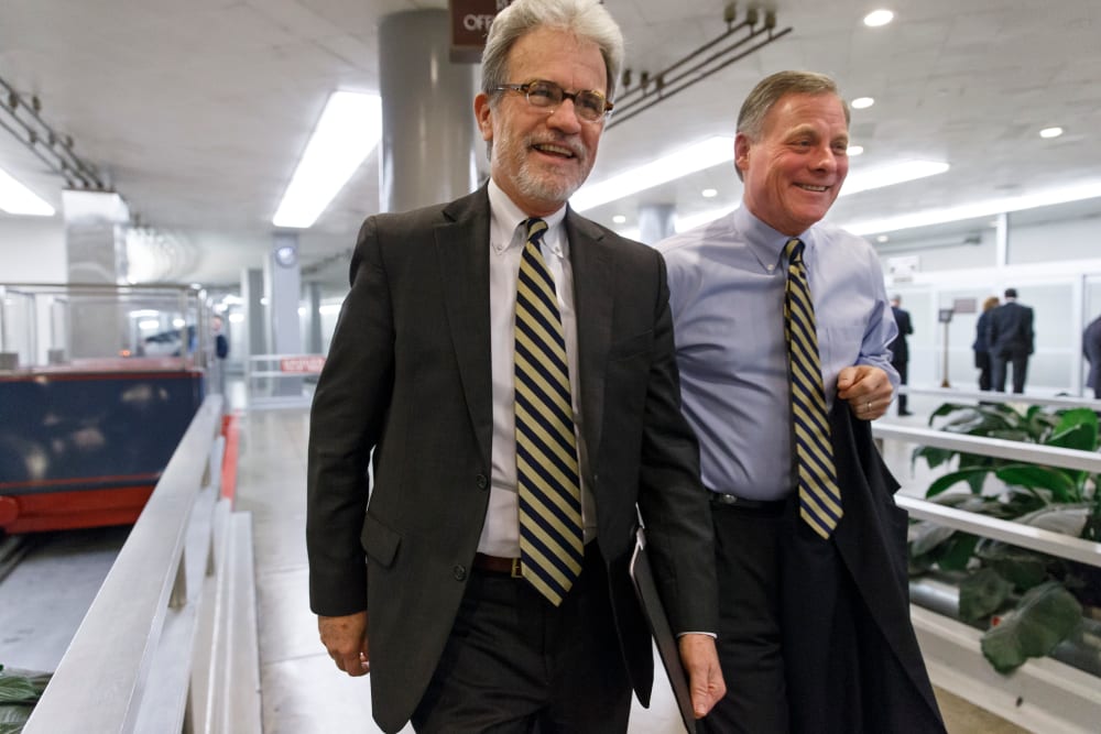 Sen. Tom Coburn, R-Okla., left, walks with Sen. Richard Burr, R-N.C., at the Capitol in Washington, Thursday, Dec. 19, 2013.