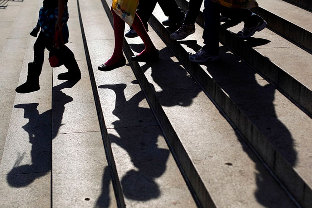 School children walk down the steps of a school.