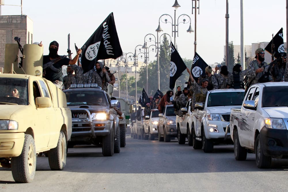 Militant Islamist fighters parade on military vehicles along the streets of northern Raqqa province June 30, 2014. (Photo by Reuters)