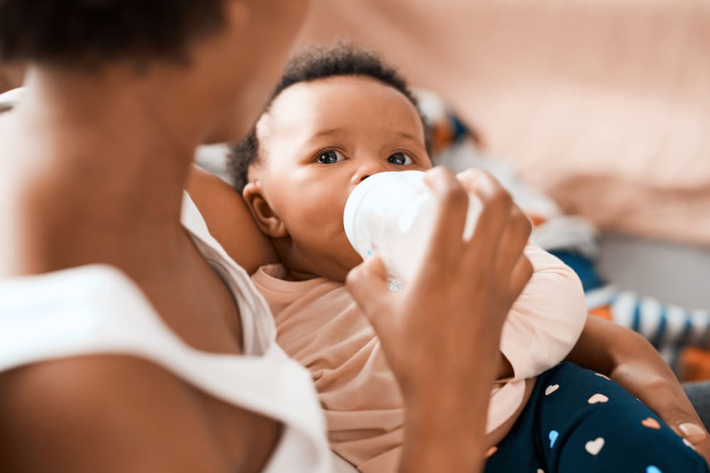Image: Shot of a mother feeding her adorable infant daughter at home