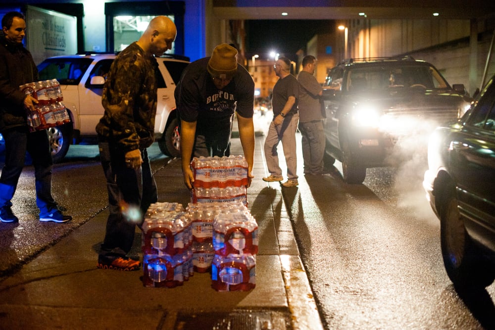 Lines of cars formed around the block as pallets of bottled water were being brought and distributed in downtown Charleston, West Virginia, Jan. 10, 2014.