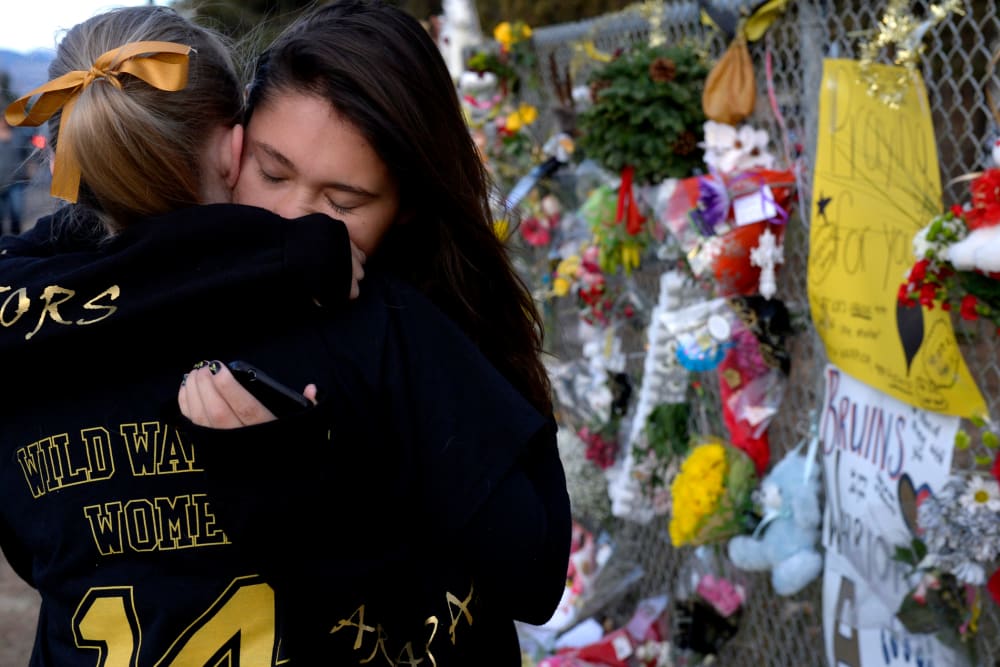 Seniors Lexi Barrent, right, and Melissa Tombaugh embrace outside Arapahoe High School in Centennial, CO Dec. 19, 2013