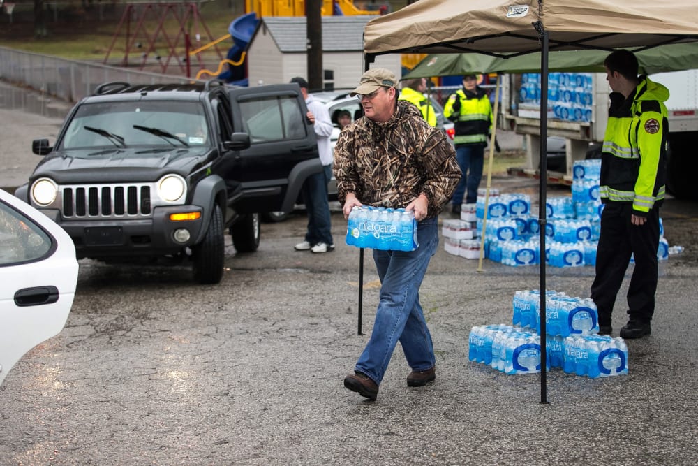 Members of the Nitro Volunteer Fire Department help to distribute bottled water to local residents Saturday Jan. 11, 2014.