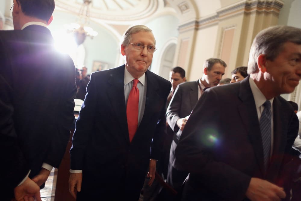 Senate Minority Leader Mitch McConnell (R-KY) (C) leaves after talking with reporters at the U.S. Capitol on Jan. 28, 2014 in Washington, DC.