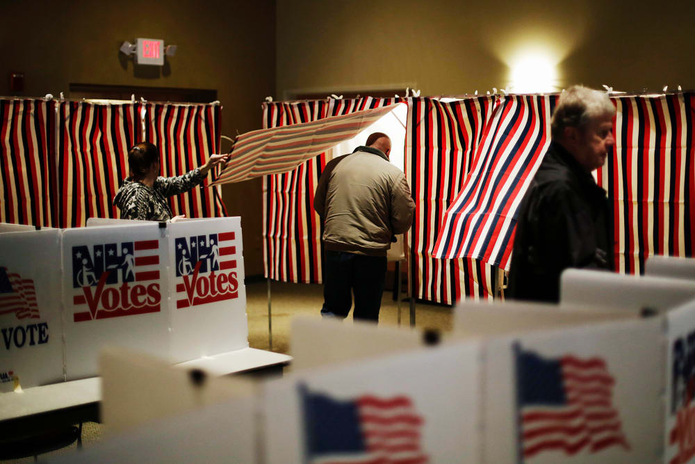 A voter steps into a voting booth to mark his ballot at a polling site for the New Hampshire primary, Feb. 9, 2016, in Nashua, N.H. (Photo by David Goldman/AP)