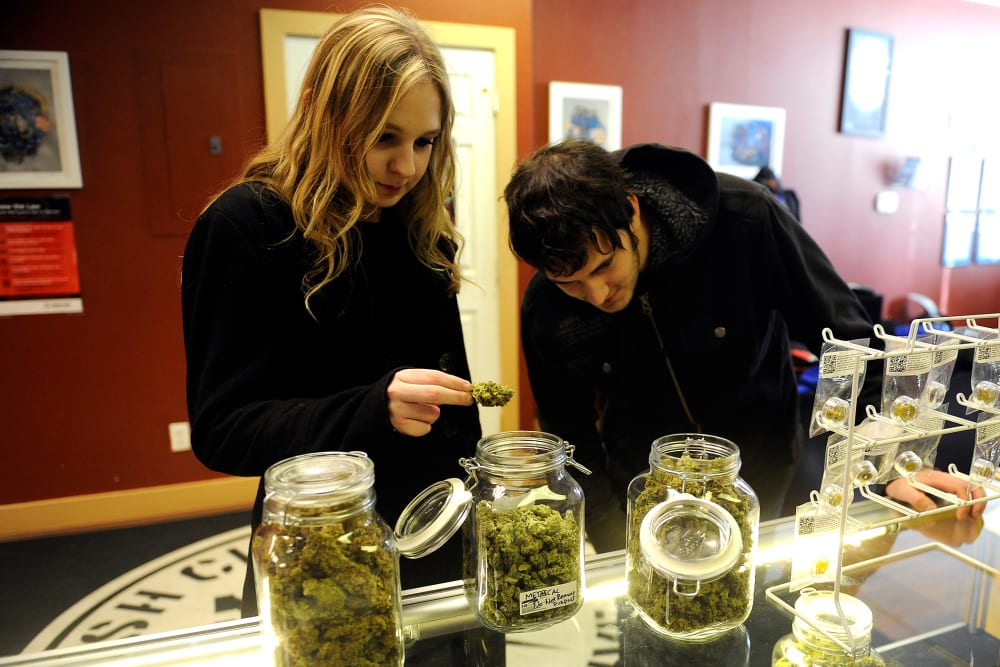 Austin Labry and Kelsey K. check out the selection of wax and shatters at Denver Kush Club, Jan. 1, 2014.