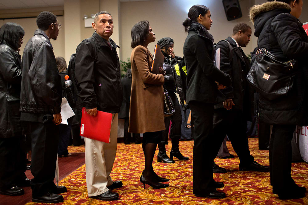 Job seekers wait to talk to recruiters and fill out applications at a job fair in New York, U.S., on Jan. 16, 2014.