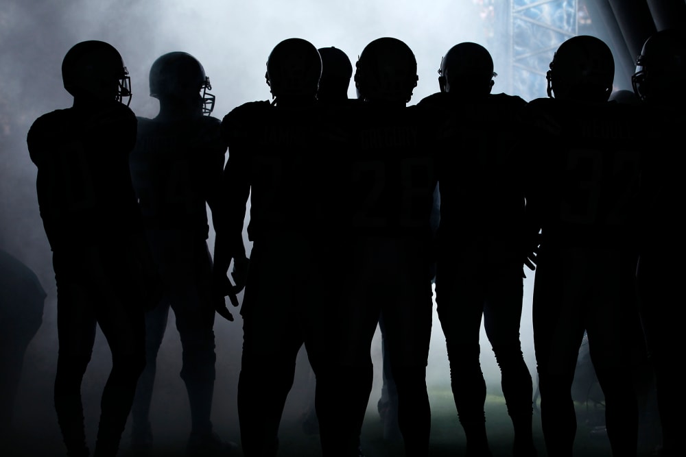 NFL players wait to be introduced to the crowd before playing in a game. (Photo by Mike Blake/Reuters)