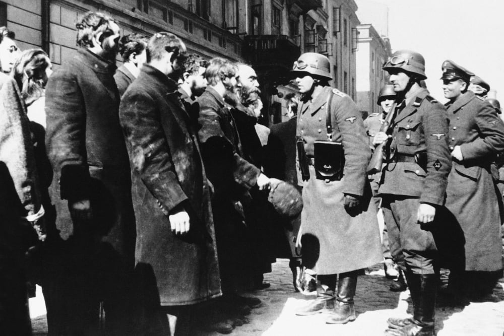 Nazi officers talk with citizens of the Warsaw ghetto, Poland, spring 1943. (Photo by AP)