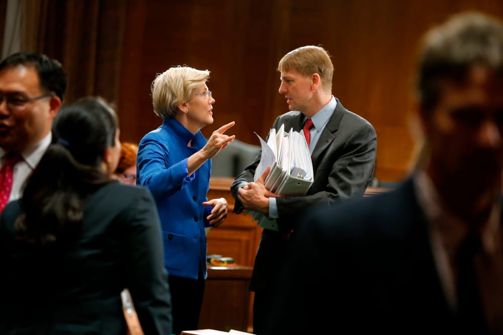 U.S. Senator Warren talks with U.S. Consumer Financial Protection Bureau Director Cordray after he testified about Wall Street reform before a Senate Banking Committee hearing on Capitol Hill in Washington