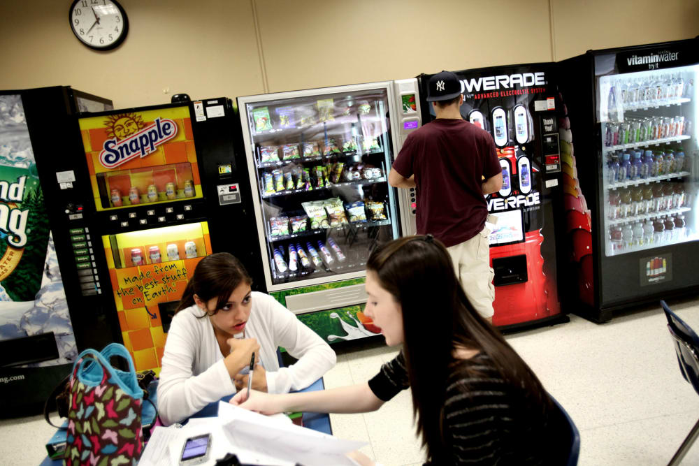 A student selects baked potato chips from a vending machine at Commack High School in Commack, N.Y., Sept. 19, 2011.