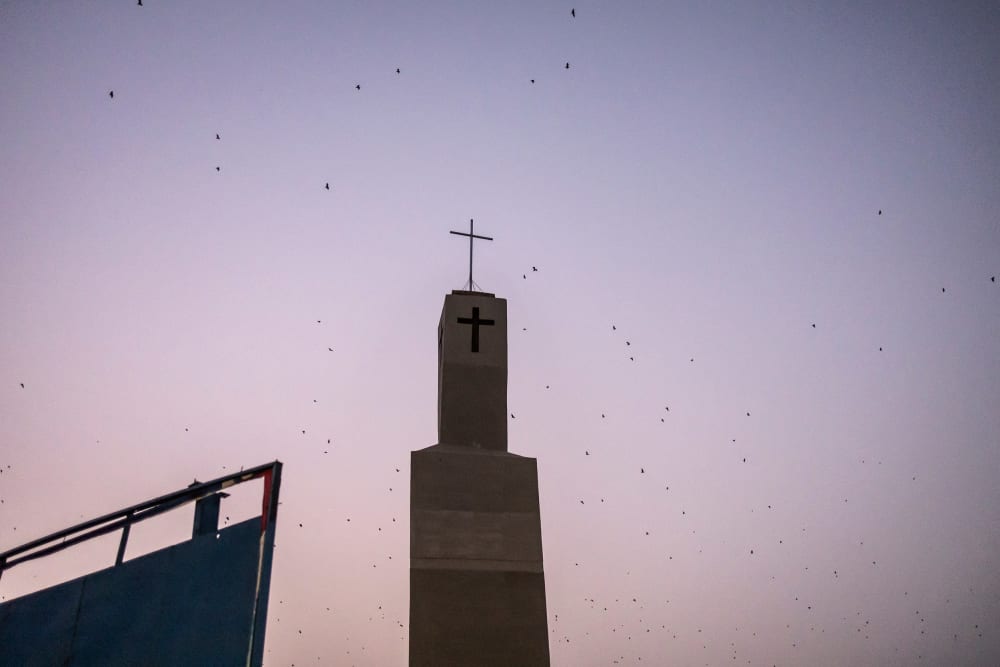 Bats fly over a church tower in Jos, Nigeria.