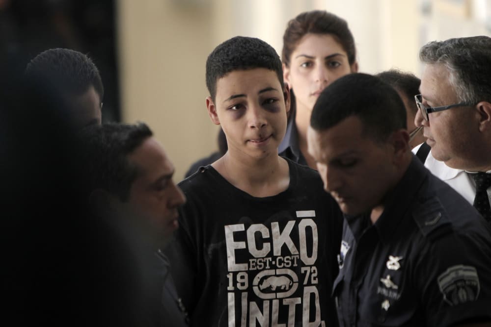 Tariq Abu Khder (C), a Palestinian-US teenager who was allegedly beaten during police custody, arrives for a hearing at Jerusalem Magistrates Court on July 6, 2014.