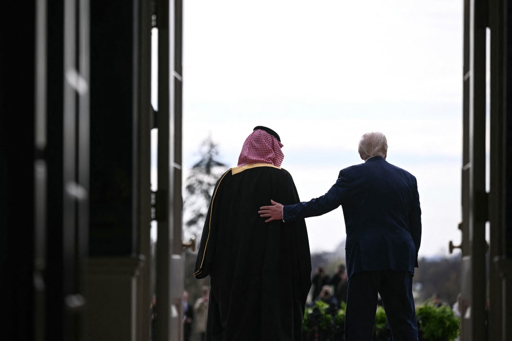 From behind, President Donald Trump greets Saudi Arabia's Crown Prince Mohammed bin Salman with a hand on his back, at the White House.