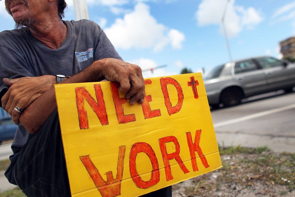 Man works a street corner hoping to land a job.