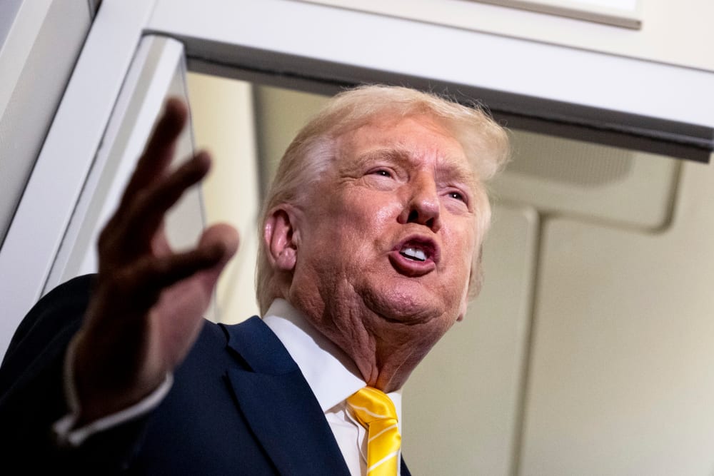 U.S. President Donald Trump speaks to members of press aboard Air Force One.
