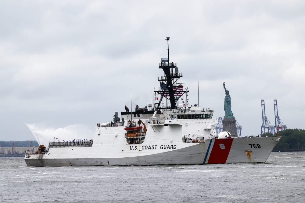 A Coast Guard ship sails past the Statue of Liberty.
