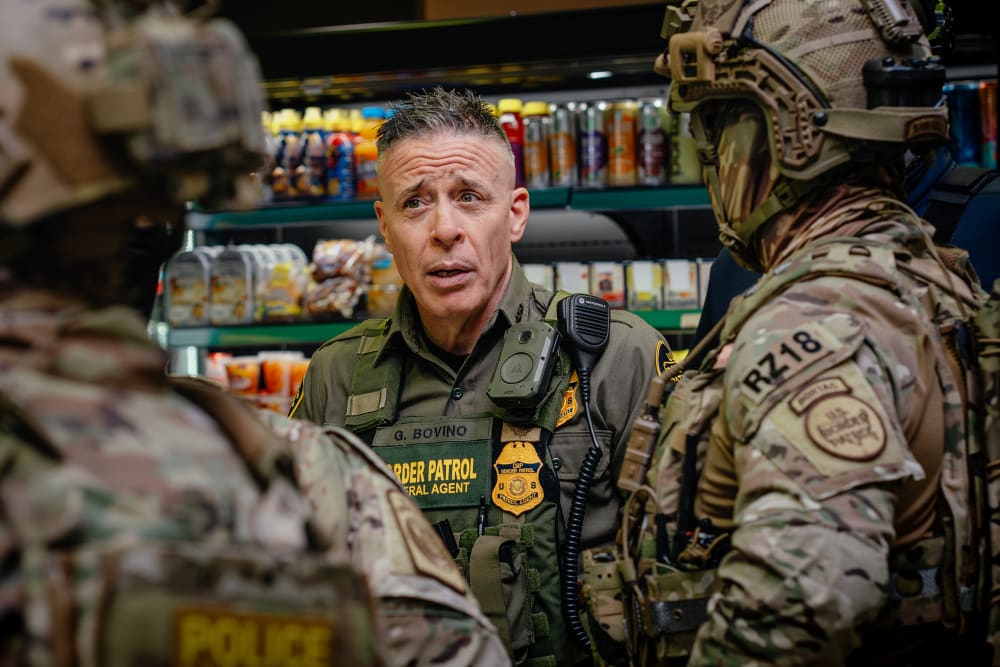 Gregory Bovino talks with other federal agents.