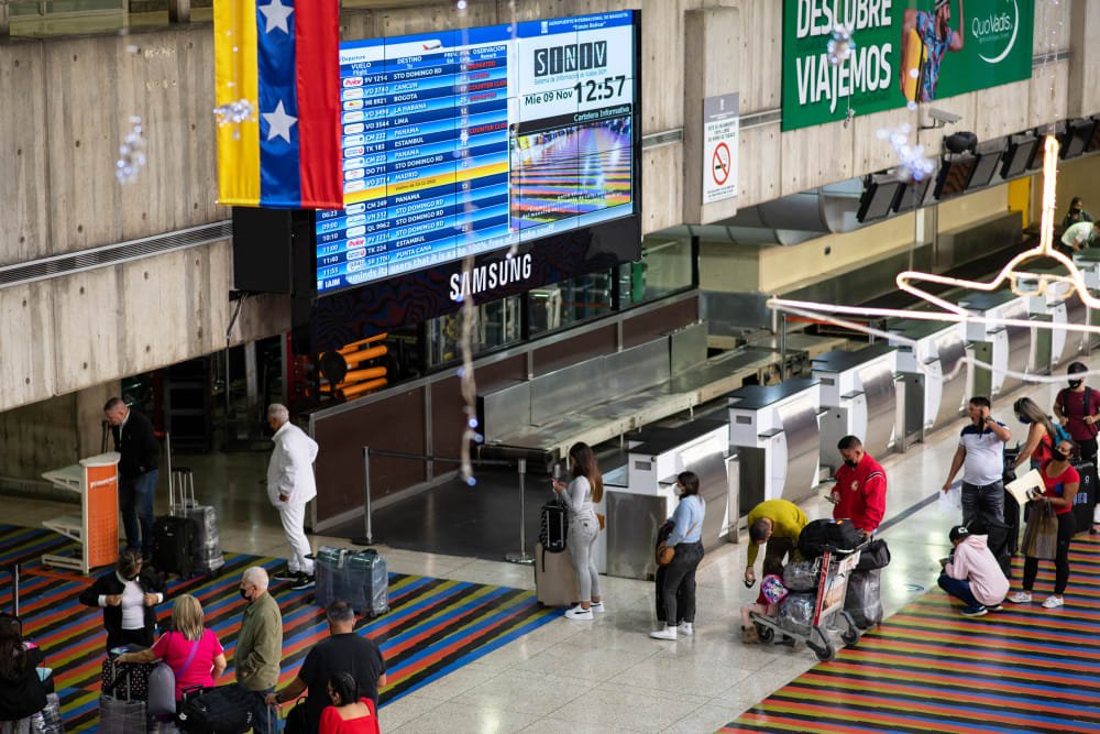 Travelers wait in line to check in for flights at the Simón Bolívar International Airport in Venezuela.