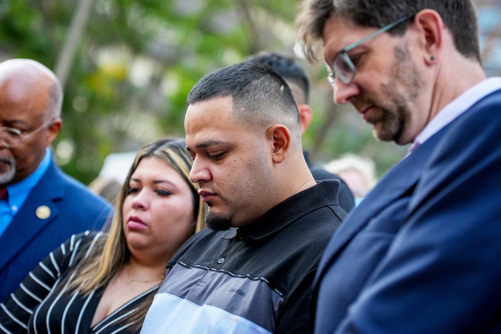 Kilmar Abrego Garcia (C), Rep. Glenn Ivey (L), Garcia's wife Jennifer Vasquez Sura (2nd-L), and his lawyer Simon Sandoval-Moshenberg (R) participates in a prayer vigil for him before he enters a U.S. Immigration and Customs Enforcement (ICE) field office.