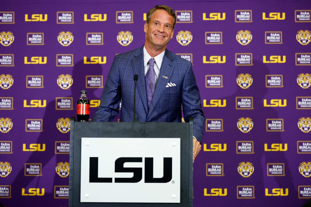 Lane Kiffin stands behind a podium at a press conference at Tiger Stadium in Baton Rouge, L.A.