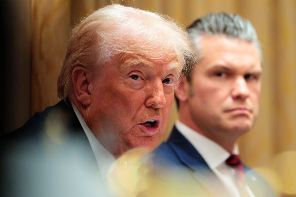 U.S. Secretary of War Pete Hegseth (R) looks on as U.S. President Donald Trump speaks during a meeting of his Cabinet.