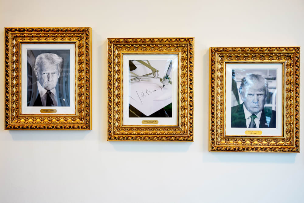 Framed portraits of President Donald Trump flank an image of former President Joe Biden's signature and an autopen along "The Presidential Walk of Fame" at the White House.