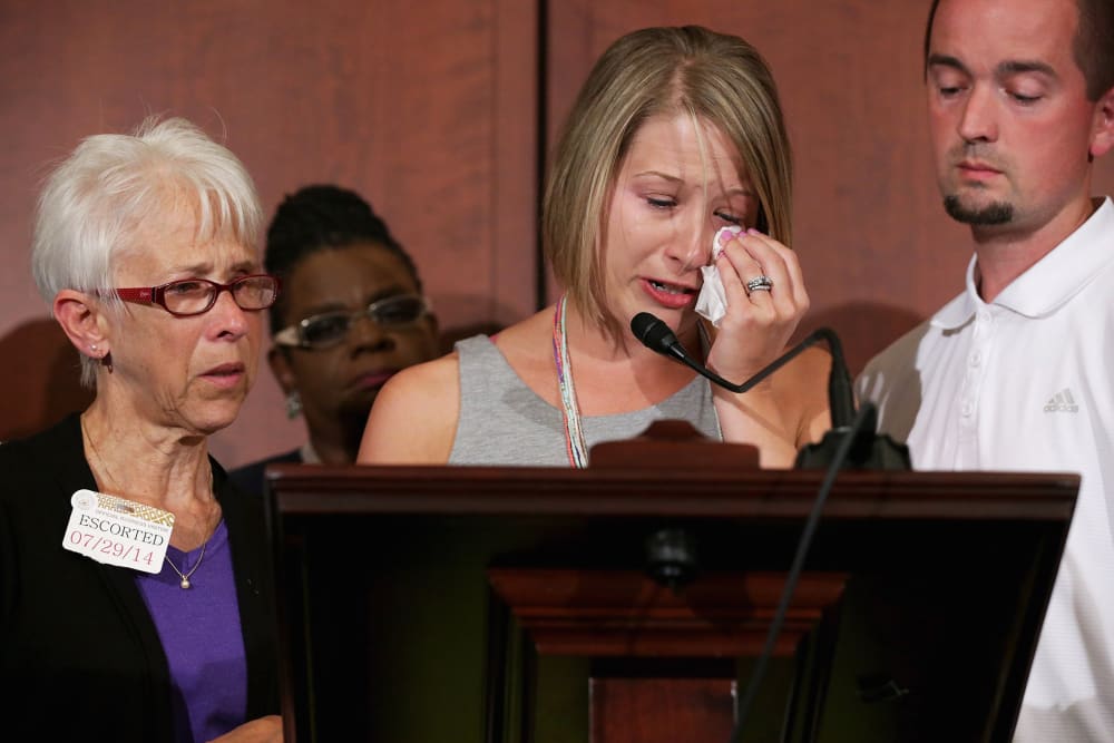 Kacey Mason (C) delivers remarks with her mother Merry Jackson (L), 63, and her husband Dave Mason during a news conference announcing new domestic violence legislation at the U.S. Capitol July 29, 2014 in Washington, DC.