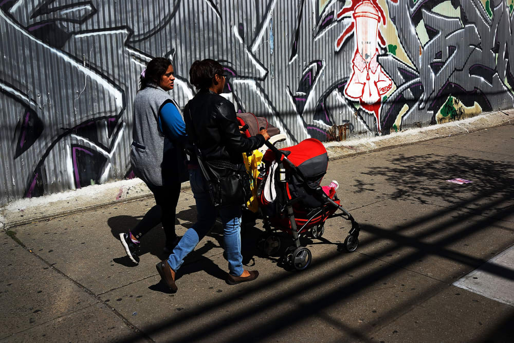 Two women walk down a street in the South Bronx, Sept. 19, 2013.