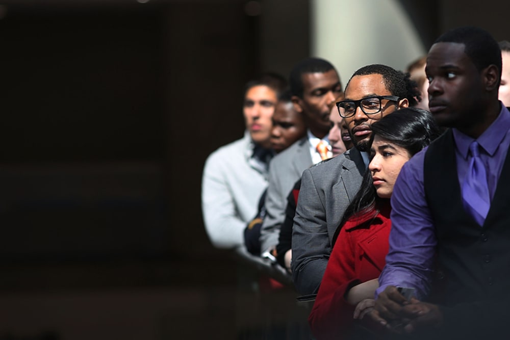 Job seekers wait in line to meet with employers at a job fair in NYC, April 26, 2013.